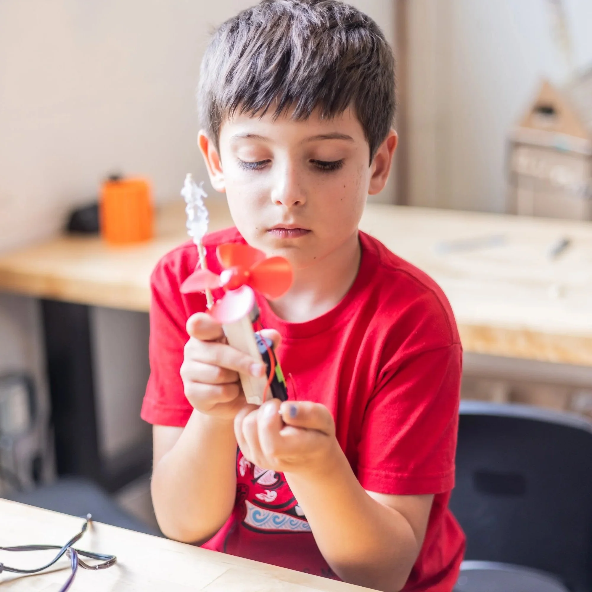 A kid holding up a project they just finished building.